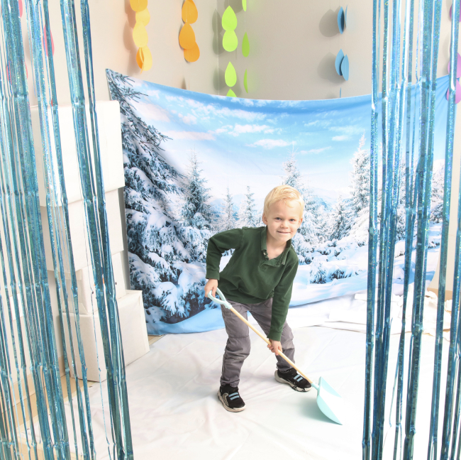 young boy with a play snow shovel